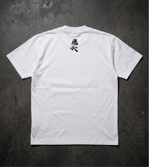 White t-shirt with black Japanese characters on the back, laid flat on a gray textured surface