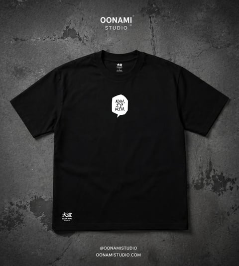 Black t-shirt with white speech bubble graphic and Japanese characters, displayed on textured gray background