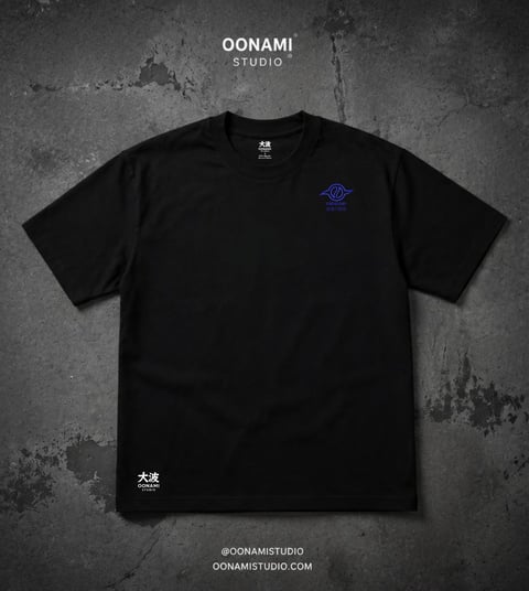 Black t-shirt with small blue logo on chest displayed on textured gray background with OONAMI Studio branding